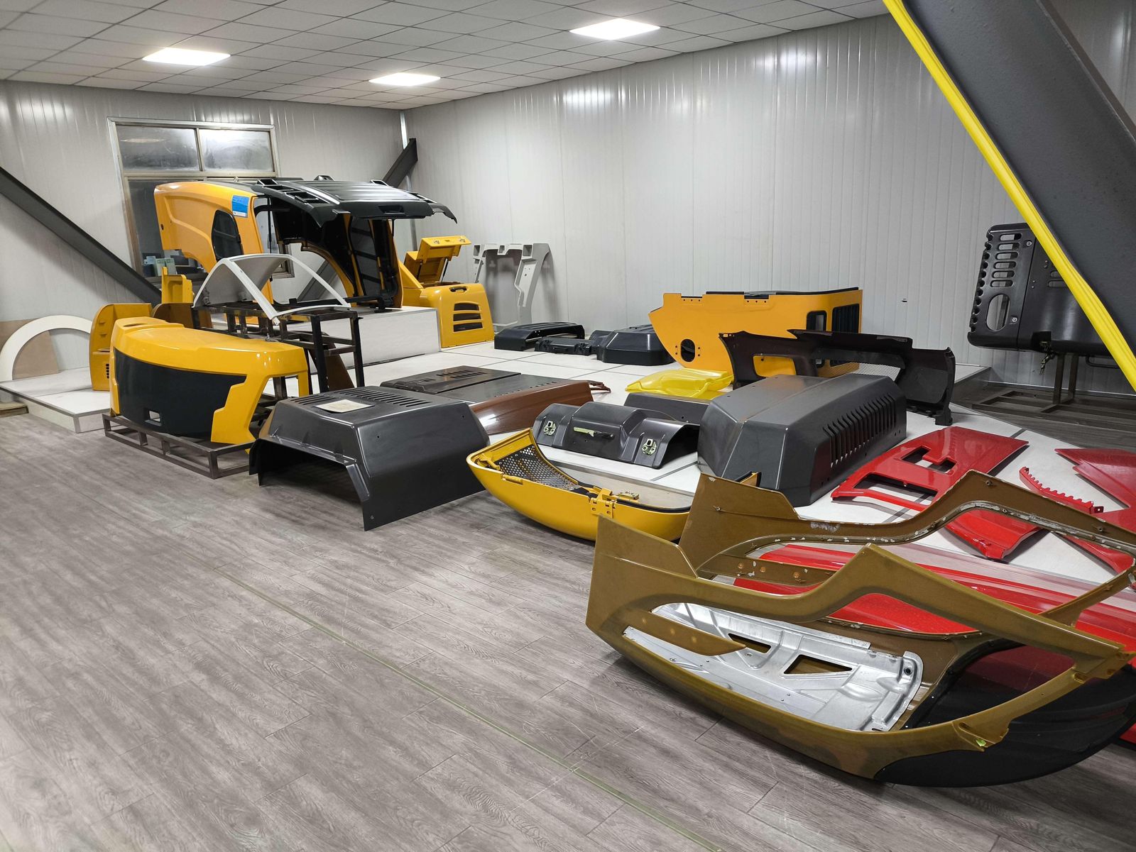 Painted PDCPD exterior panels for construction machinery laid out in a sample room